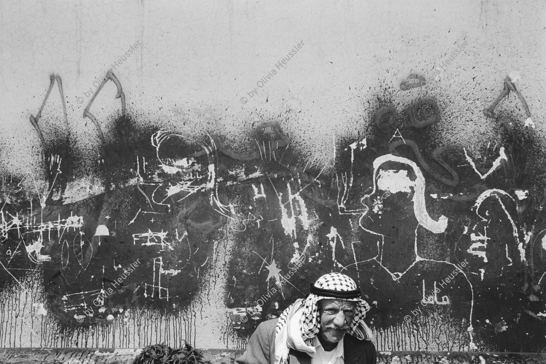 Image of sheet 19920400 photo 4: Ein Palästinenser mit Kopftuch Keffiyeh sitzt vor einer verkratzten Hauswand in der Altstadt Jerusalems. Palästina Israel Palestine 1992 √
alter Mann Mural Kopfbedeckung Kufiya Portrait

copyright by Olivia Heussler  Graffiti

old Palestinian with Keffiyeh sitting in front of a scratched wall in the Old City of Jerusalem.
Aus: Out of Jerusalem / Jenseits von Jerusalem page 47