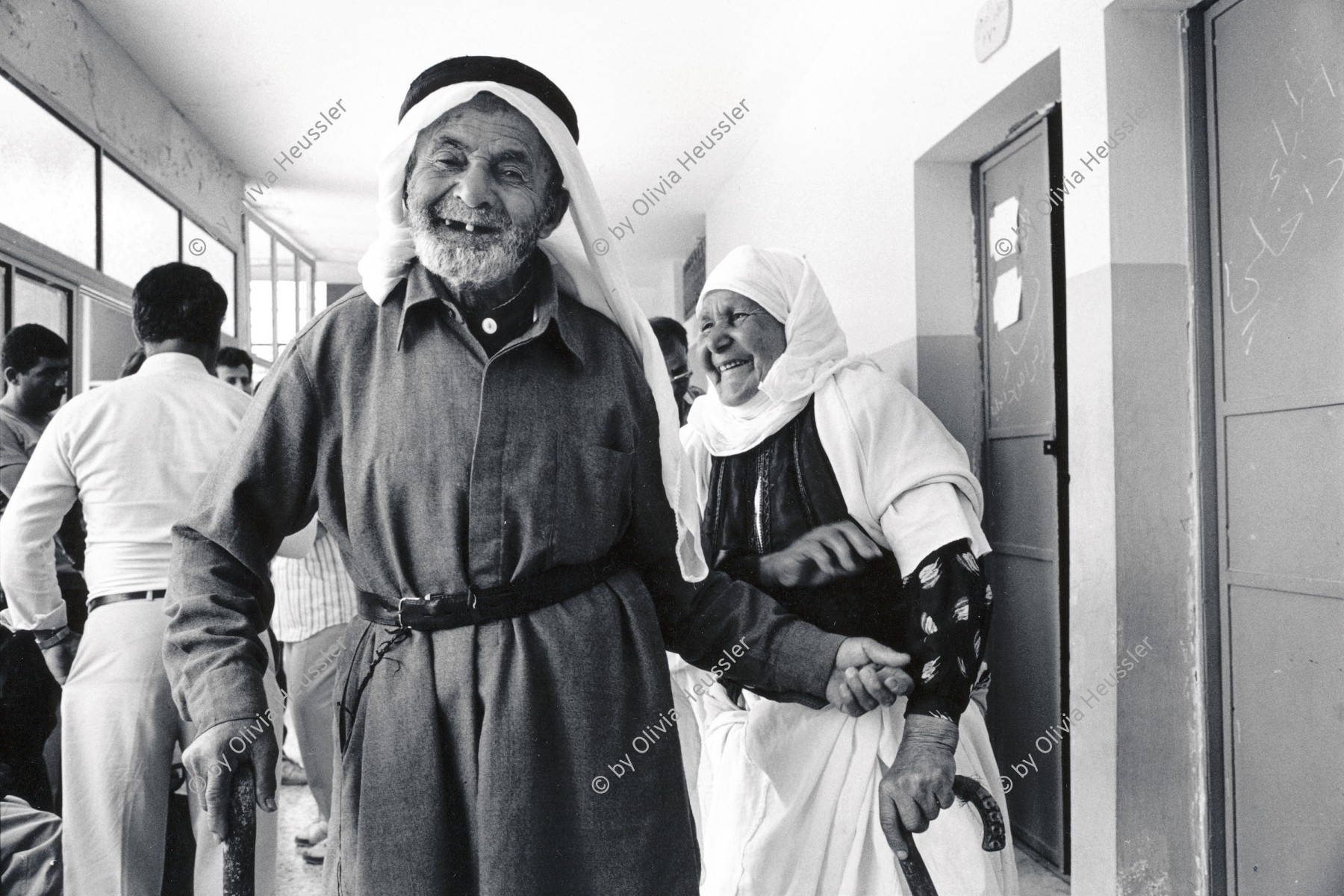 Image of sheet 19920410 photo 21: © 1992, OLIVIA HEUSSLER/ www.clic.li
Aelteres palästinensisches Ehepaar wartet auf die israelische Aerztin. Anabta, Westbank, Palästina 1992 Palestine

An old Palestinian couple 
waiting to be examined and treated by an 
waits for the Israeli doctor. Anabta. 1992 √ Human rights Health care older People occupied territories

Anabta (Arabic: عنبتا‎) is a Palestinian town in the Tulkarm Governorate in the northern West Bank, located 9 kilometers east of Tulkarm. According to the Palestinian Central Bureau of Statistics, Anabta had a population of 7,329 inhabitants in 2007.[1] Anabta is administered by a municipal council and is one of the oldest municipalities in the Tulkarm Governorate.[2] The town has an urban area of about 1,300 dunams. Most of its exterior lands are planted with olives, figs and almonds or covered by forests. Water is provided by five underground wells, with distribution supervised by the town's municipality

Aus: Out of Jerusalem / Jenseits von Jerusalem page 63

zurück von Libération, Paris 2015