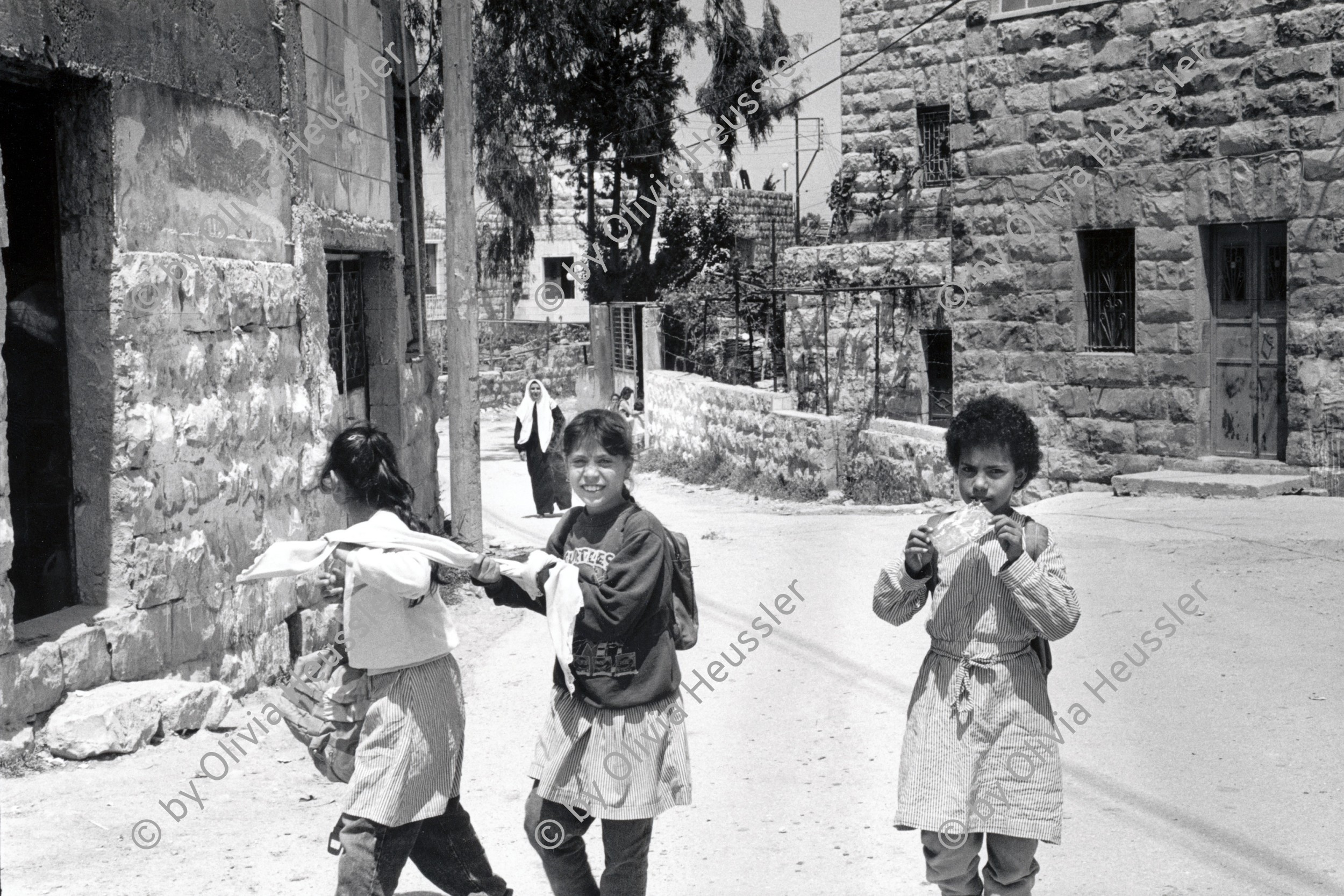 Image of sheet 19920420 photo 33: © 1992, OLIVIA HEUSSLER/ www.clic.li
Schulkinder auf dem Heimweg in Beit Suriq, Westbank Palästina 05.92 1992 √
school kids girls uniforms palestinian palestine occupied territory

Beit Surik (Arabic: بيت سوريك‎) is a Palestinian village in the Jerusalem Governorate, located 12 kilometers Northwest of Jerusalem in the northern West Bank. According to the Palestinian Central Bureau of Statistics, the town had a population of 3,818 in 2006