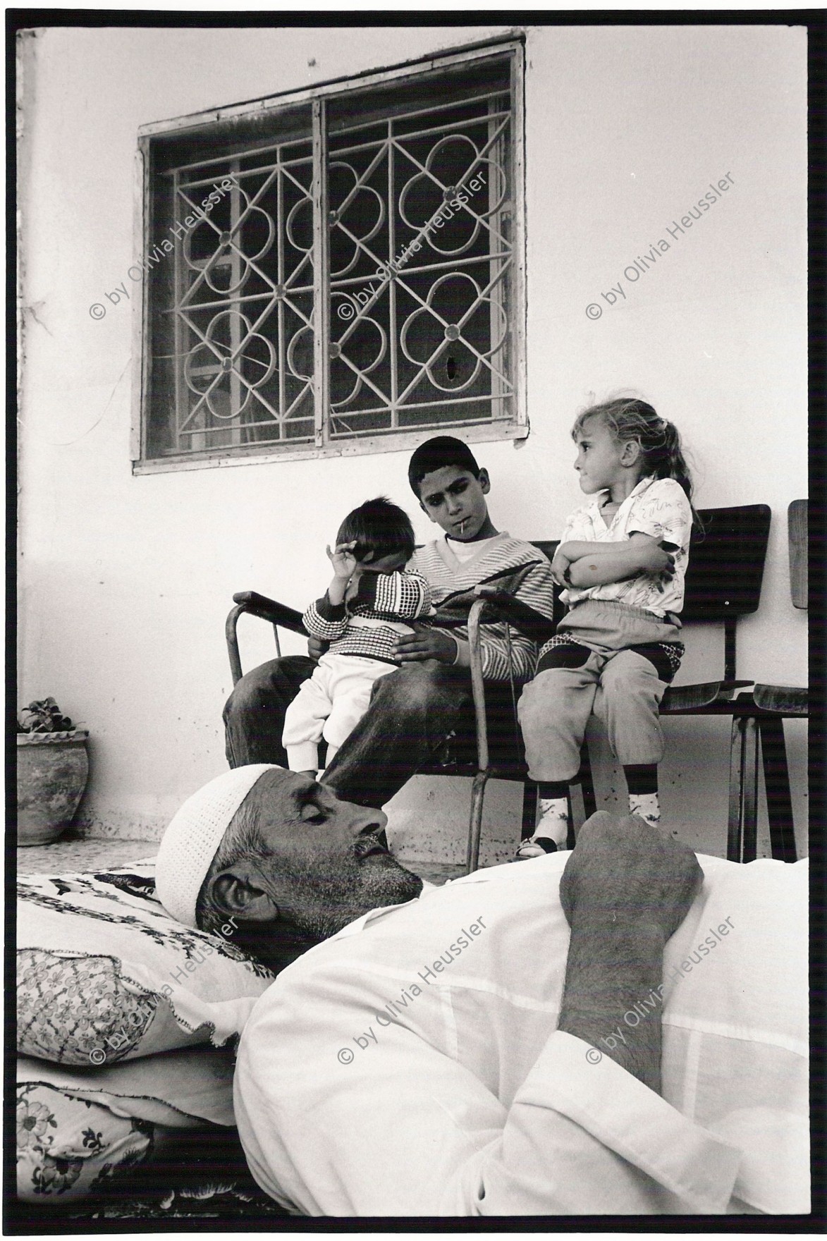 Image of sheet 19920430 photo 8: Alter Mann krank Patient wartet auf die Physiotherapeutin Physiotherapy Palästinenser eine Behandlung. Er liegt am Boden zu Hause. Palestine 1992
West bank occupied territory Beit Suriq old man on the floor 


Beit Surik (Arabic: بيت سوريك‎) is a Palestinian village in the Jerusalem Governorate, located 12 kilometers Northwest of Jerusalem in the northern West Bank. According to the Palestinian Central Bureau of Statistics, the town had a population of 3,818 in 2006.
zurück von Libération, Paris 2015