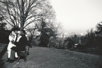 Image of sheet 19920710 photo 24: Ein farbiges Liebespaar sonnt sich im Parc des Buttes Chaumont. Paris, 1992. Frankreich France √ Park Bank Liebe Love paar 
Sicht auf die Stadt.