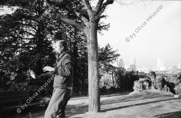 Image of sheet 19920710 photo 31: Ausstellung Alis Guggenheim im Kunsthaus Aarau. Plastiken. Familie mit Katz und Pack im Zug nach Paris. Selbstportrait Spiegel Cité in Paris Olivia. Mit Portrait Dominique Meienberg Fotograf und Cousin von schriftsteller Niklaus Meienberg. im Parc  des Buttes Chaumont. Aikido Mensch Japaner macht Aikido Uebungen Hintergrund Dächer von Paris. Farbiges Liebespaar Junge Sonnen sich.  France Frankreich 1992