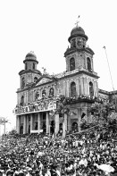 Image of sheet 19930400 photo 14: Kathedrale auf dem Revolutionsplatz.
Managua, 19. Juli 1993
Während der Feierlichkeiten des 14 Jahrestages der sandinistischen Revolution in Managua am 19. Juli 1993

Durante las celebraciones del 14° aniversario de la Revolución sandinista. Plaza de la Revolución, Managua, 19 de julio de 1993
Celebrating the 14th anniversary of the Sandinista revolution. Plaza of the Revolution, Managua, 1993


Menschenmassen Protest Demonstration Jubeln Feier am 19.7.93 auf der Plaza de la Revolucion, vor der Cathedrale Kathedrale: Managua ( 14. Jahrestag der sandinistischen Revolution ) FSLN Nicaragua 1993 √ 19. Juli 1993
'Muerte al Somocismo' Steht auf dem Banner. Sandinistische flaggen und Fahnen.
Die Kathedrale Santiago de Managua ist die Ruine der alten Kathedrale von Managua. Sie befindet sich an der Plaza de la Revolution, vormals Plaza de la República. Sie wurde als kaschierter Stahlskelettbau im neoklassischen Stil errichtet. Die Fassadenaufteilung ist ähnlich der von St-Sulpice de Paris.

Aus: «Der Traum von Solentiname» EPF, Zürich 
«El Sueño de Solentiname» IHNCA Managua p.138
