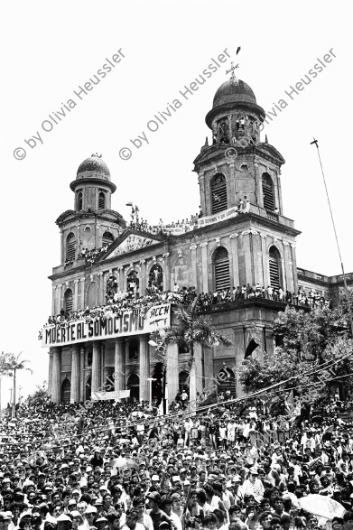 Image of sheet 19930400 photo 14: Kathedrale auf dem Revolutionsplatz.
Managua, 19. Juli 1993
Während der Feierlichkeiten des 14 Jahrestages der sandinistischen Revolution in Managua am 19. Juli 1993

Durante las celebraciones del 14° aniversario de la Revolución sandinista. Plaza de la Revolución, Managua, 19 de julio de 1993
Celebrating the 14th anniversary of the Sandinista revolution. Plaza of the Revolution, Managua, 1993


Menschenmassen Protest Demonstration Jubeln Feier am 19.7.93 auf der Plaza de la Revolucion, vor der Cathedrale Kathedrale: Managua ( 14. Jahrestag der sandinistischen Revolution ) FSLN Nicaragua 1993 √ 19. Juli 1993
'Muerte al Somocismo' Steht auf dem Banner. Sandinistische flaggen und Fahnen.
Die Kathedrale Santiago de Managua ist die Ruine der alten Kathedrale von Managua. Sie befindet sich an der Plaza de la Revolution, vormals Plaza de la República. Sie wurde als kaschierter Stahlskelettbau im neoklassischen Stil errichtet. Die Fassadenaufteilung ist ähnlich der von St-Sulpice de Paris.

Aus: «Der Traum von Solentiname» EPF, Zürich 
«El Sueño de Solentiname» IHNCA Managua p.138