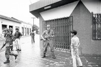 Image of sheet 19930410 photo 5: © 1993, Olivia Heussler / www.clic.li
Besetzung am 21. Juli 1993 von Esteli durch mit AK-47 bewaffnete des Frente Revolucionario Obrero y Campesino. Unter Führung von Recompa Pedrito el Hondureño alias Victor Gallegos  unter Verwendung von RPG-7 Granatwerfer und RPK und Mörser M-79 45 Tote und 98 Verwundete. Banküberfall an der Esquina de los Bancos in Esteli. Beute: 4 Millionen Cordobas. FROC Soldat bittet Wasser von Zivilist. Kleinbus für Geldtransport. Zivile. Bankangestellte verlassen Gebäude. Zivile bauen Barrikaden. Frauen. Zivile hören Radio. Nr. 28 erscheint in Barricada. Nicaragua 1993 √

AK-47 ist die Abkürzung für Awtomat Kalaschnikowa, obrasza 47 (kyrillisch Автомат Калашникова образца 47), ein sowjetisch-russisches Sturmgewehr. Es ist die am meisten produzierte Handfeuerwaffe weltweit. Schätzungen gehen von 80 bis 100 Millionen produzierten Exemplaren aus. 

El FROC en el atraco al banco. Estelí, 21 de julio de 1993
FROC bank robbery. Estelí, July 21, 1993
