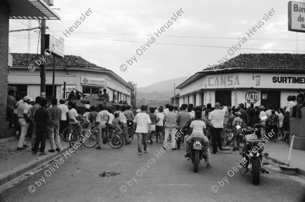 Image of sheet 19930470 photo 1: Das Militär (EPS) zieht in einem Konvoi aus Esteli ab Ein Paar in der Strasse. Frauen putzen die blut verschmierten Böden des Spitals. Angehörige suchen vermisste. Die ausgeraubte Bank. Teile der Barrikade. Auch die Bäume im Zentralpark Parque central sind mitgenommen von Einschusslöchern. Petroglyphen am Strassenrand. u.a. der Brujito. El Esteli Segovias Nicaragua 1993