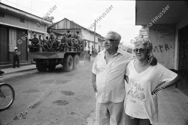 Image of sheet 19930470 photo 14: Das Militär (EPS) zieht in einem Konvoi aus Esteli ab Ein Paar in der Strasse. Frauen putzen die blut verschmierten Böden des Spitals. Angehörige suchen vermisste. Die ausgeraubte Bank. Teile der Barrikade. Auch die Bäume im Zentralpark Parque central sind mitgenommen von Einschusslöchern. Petroglyphen am Strassenrand. u.a. der Brujito. El Esteli Segovias Nicaragua 1993