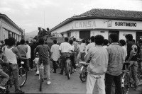 Image of sheet 19930470 photo 2: Das Militär (EPS) zieht in einem Konvoi aus Esteli ab Ein Paar in der Strasse. Frauen putzen die blut verschmierten Böden des Spitals. Angehörige suchen vermisste. Die ausgeraubte Bank. Teile der Barrikade. Auch die Bäume im Zentralpark Parque central sind mitgenommen von Einschusslöchern. Petroglyphen am Strassenrand. u.a. der Brujito. El Esteli Segovias Nicaragua 1993