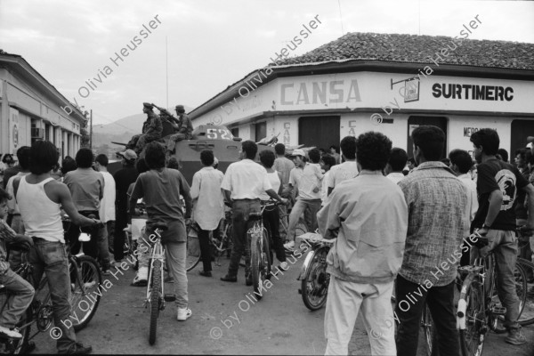 Image of sheet 19930470 photo 2: Das Militär (EPS) zieht in einem Konvoi aus Esteli ab Ein Paar in der Strasse. Frauen putzen die blut verschmierten Böden des Spitals. Angehörige suchen vermisste. Die ausgeraubte Bank. Teile der Barrikade. Auch die Bäume im Zentralpark Parque central sind mitgenommen von Einschusslöchern. Petroglyphen am Strassenrand. u.a. der Brujito. El Esteli Segovias Nicaragua 1993