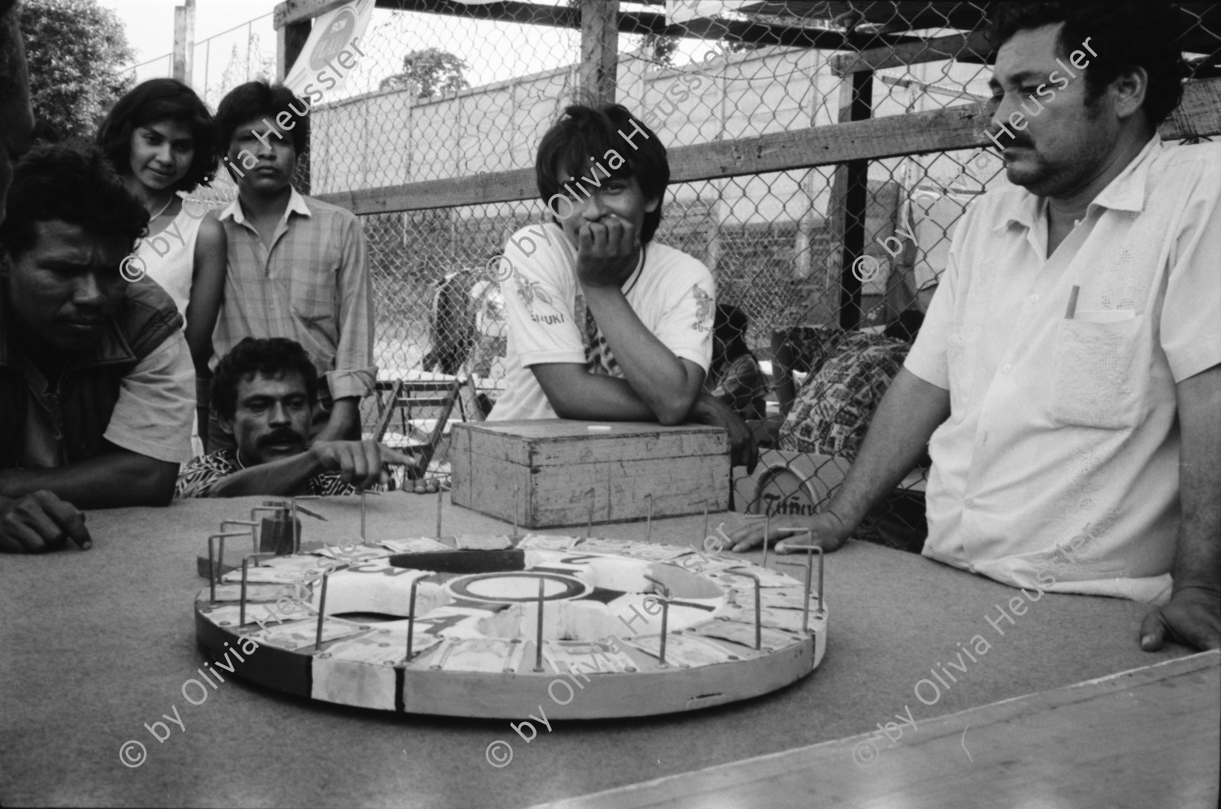 Image of sheet 19930500 photo 5: Roulette ambulante an der Vorbereitung zur Fiesta des Santo Dominguito in der
Kirche von Santo Domingo, Las Sierritas bei Managua. Karusell. mit Blechauto. Menschen sind verkleidet und tanzen in der Kirche. Beichtstuhl. Viele kriechen laut Tradition auf ihren blossen Knien zum Santos um ihren kranken Verwandten oder sich selbst Heilung zu versprechen. Ex Votos werden verkauft. Nicaragua 1993