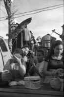 Image of sheet 19930521 photo 12: frtsg. 930520 Fiesta Santo Domingo. Frauen Tänzerinnen schminken sich. Junge Nicaraguaner sind von den Vereinigten Staaten zurückgekehrt. Heimkehrer aus den USA. Coca Cola Stand. Kids. Frau raffelt Guachada. Koch Banane.  Kirche von Santo Domingo mit Sateliten Pfanne am Kirchturm. Tänzerinnen. Apotheke Condega mit gemischten Waren Heilpflanzen sowie schulmedizinische Produkte. Nicaragua 1993 natural health medicine plants pharmacie