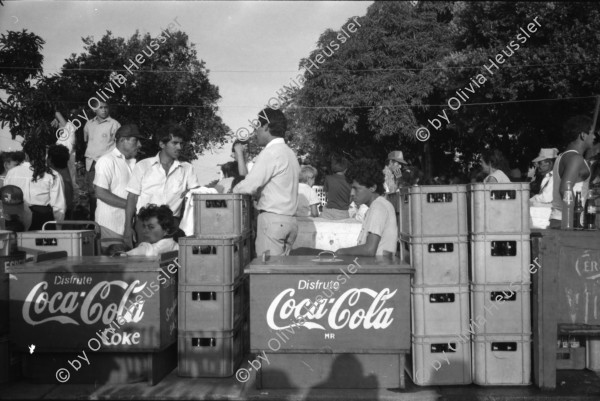 Image of sheet 19930521 photo 17: frtsg. 930520 Fiesta Santo Domingo. Frauen Tänzerinnen schminken sich. Junge Nicaraguaner sind von den Vereinigten Staaten zurückgekehrt. Heimkehrer aus den USA. Coca Cola Stand. Kids. Frau raffelt Guachada. Koch Banane.  Kirche von Santo Domingo mit Sateliten Pfanne am Kirchturm. Tänzerinnen. Apotheke Condega mit gemischten Waren Heilpflanzen sowie schulmedizinische Produkte. Nicaragua 1993 natural health medicine plants pharmacie