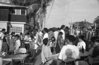 Image of sheet 19930521 photo 2: frtsg. 930520 Fiesta Santo Domingo. Frauen Tänzerinnen schminken sich. Junge Nicaraguaner sind von den Vereinigten Staaten zurückgekehrt. Heimkehrer aus den USA. Coca Cola Stand. Kids. Frau raffelt Guachada. Koch Banane.  Kirche von Santo Domingo mit Sateliten Pfanne am Kirchturm. Tänzerinnen. Apotheke Condega mit gemischten Waren Heilpflanzen sowie schulmedizinische Produkte. Nicaragua 1993 natural health medicine plants pharmacie