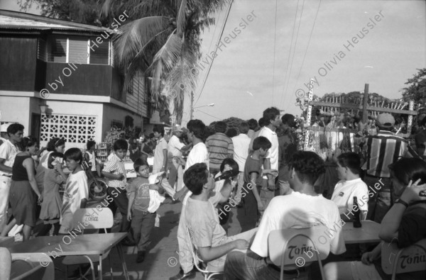 Image of sheet 19930521 photo 2: frtsg. 930520 Fiesta Santo Domingo. Frauen Tänzerinnen schminken sich. Junge Nicaraguaner sind von den Vereinigten Staaten zurückgekehrt. Heimkehrer aus den USA. Coca Cola Stand. Kids. Frau raffelt Guachada. Koch Banane.  Kirche von Santo Domingo mit Sateliten Pfanne am Kirchturm. Tänzerinnen. Apotheke Condega mit gemischten Waren Heilpflanzen sowie schulmedizinische Produkte. Nicaragua 1993 natural health medicine plants pharmacie