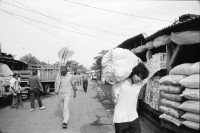 Image of sheet 19930680 photo 12: frtsg. 930670 Mercado Oriental Verkäufer. Betrieb Markt. Alte Frau mit Ruda im Korb und in den Haaren. Korb mit Hähnchen. Kontrollgang eines Polizisten. Managua Nicaragua 1993