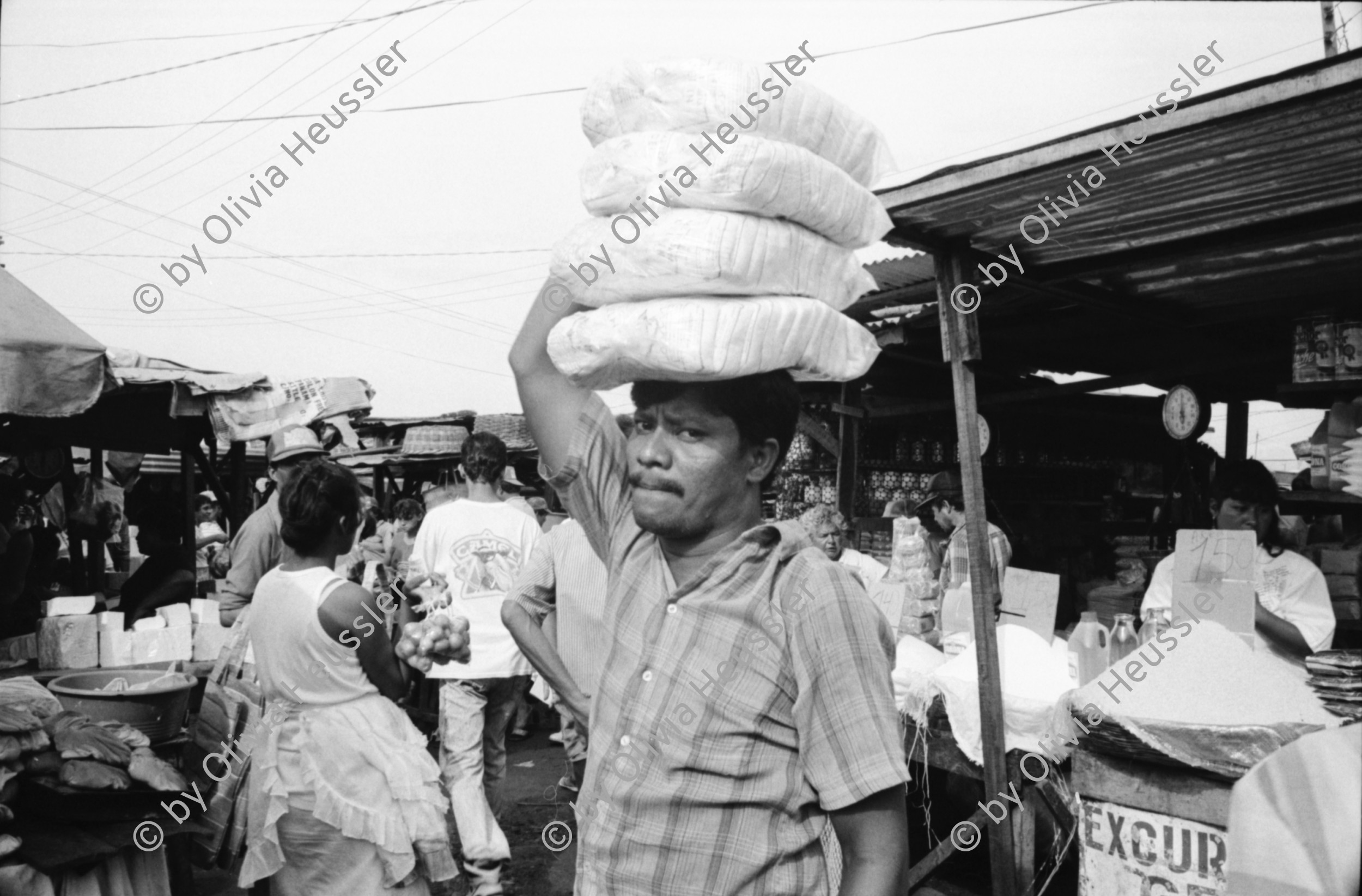 Image of sheet 19930680 photo 17: frtsg. 930670 Mercado Oriental Verkäufer. Betrieb Markt. Alte Frau mit Ruda im Korb und in den Haaren. Korb mit Hähnchen. Kontrollgang eines Polizisten. Managua Nicaragua 1993