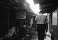 Image of sheet 19930680 photo 36: frtsg. 930670 Mercado Oriental Verkäufer. Betrieb Markt. Alte Frau mit Ruda im Korb und in den Haaren. Korb mit Hähnchen. Kontrollgang eines Polizisten. Managua Nicaragua 1993