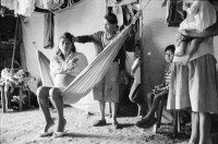 Image of sheet 19930780 photo 9: frtsg. 930740 Doña Hebamme Maria betreut eine junge Frau Sandra in der Hängematte. im Holzhaus. Barake. Sie zeigt mir ihre Arbeitsutensilien. vor ihrem häuschen. und drinnen. auf dem Weg nach Esteli. Frau mit Schirm Pantasma mit Polin und Riccardo Salinas Valdivia 
Esteli Nicaragua 1993 Lindavista