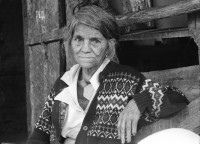 Image of sheet 19930810 photo 28: Juan Alberto, links und sein Patenkind (!) Gregorio Canales Rodriguez. Dona Carmen Acebedo, 70.Pueblo Nuevo, behandelt ein kleiner Junge, der an Empacho leidet. Sie reibt seine Gliedchen und den Bauch mit Ziegenfett ein. Die Wärme soll ihm gut tun. Der Vater des Kindes sitzt eng neben dona Carmen und lässt es nicht allein. Portrait.mit Bouanerge Tercero. Nicaragua 1993 Curandero curar Healer healing medical traditional natural
