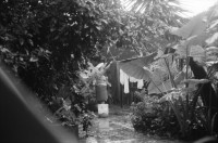 Image of sheet 19930830 photo 27: Pedro, zweiter Chef vom Frente Revolucionario Obrero y Campesino FROC aus Regadio und Pedrito el Hondureno, Victor Gallegos Nr. 18 und der Estado Mayor in der Zona Enclave San Jeronimo. Im Hof vom Haus von Juanita Anita hängt im Regen ihre Wäsche auf. Die Brücke ist zusammengestürzt. Junge springen vom Rest der Brücke in die Fluten. Nicaragua Esteli 1993