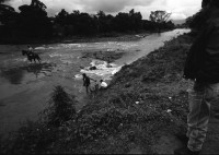 Image of sheet 19930830 photo 35: Pedro, zweiter Chef vom Frente Revolucionario Obrero y Campesino FROC aus Regadio und Pedrito el Hondureno, Victor Gallegos Nr. 18 und der Estado Mayor in der Zona Enclave San Jeronimo. Im Hof vom Haus von Juanita Anita hängt im Regen ihre Wäsche auf. Die Brücke ist zusammengestürzt. Junge springen vom Rest der Brücke in die Fluten. Nicaragua Esteli 1993