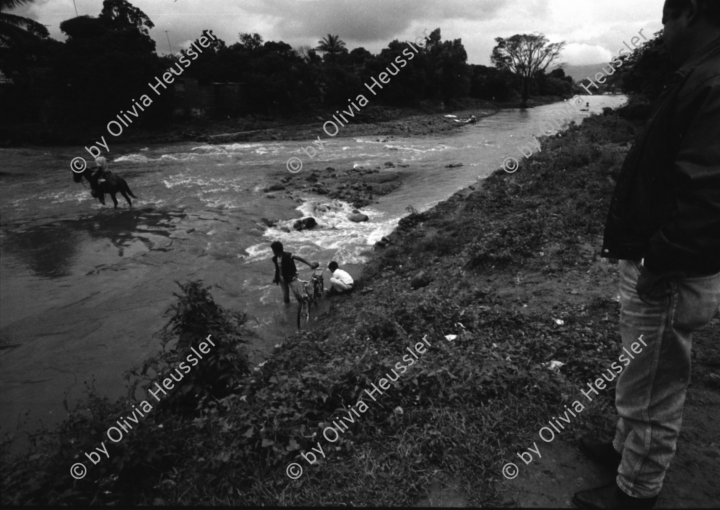 Image of sheet 19930830 photo 35: Pedro, zweiter Chef vom Frente Revolucionario Obrero y Campesino FROC aus Regadio und Pedrito el Hondureno, Victor Gallegos Nr. 18 und der Estado Mayor in der Zona Enclave San Jeronimo. Im Hof vom Haus von Juanita Anita hängt im Regen ihre Wäsche auf. Die Brücke ist zusammengestürzt. Junge springen vom Rest der Brücke in die Fluten. Nicaragua Esteli 1993