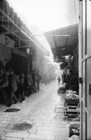 Image of sheet 19931210 photo 15: Mea Shearim Lutfi's Peace Land Galery in Ost- Jerusalem Altstadt. Regen in Altstadt. Am Markt Israeli Soldaten beobachten vom Damaskus Tor aus. Brotverkäufer. Rachel Freudenthal Portrait vor Spray Graffitti und beim einkaufen auf dem Shouk in Jerusalem mit Tochter Noa. Araber telefoniert und orthodoxe Juden nach dem Gebet am Shabes. Araber untersucht neue Unterhosen. Israel Palästina 1993