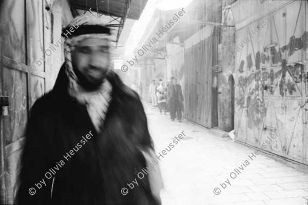 Image of sheet 19931210 photo 18: Mea Shearim Lutfi's Peace Land Galery in Ost- Jerusalem Altstadt. Regen in Altstadt. Am Markt Israeli Soldaten beobachten vom Damaskus Tor aus. Brotverkäufer. Rachel Freudenthal Portrait vor Spray Graffitti und beim einkaufen auf dem Shouk in Jerusalem mit Tochter Noa. Araber telefoniert und orthodoxe Juden nach dem Gebet am Shabes. Araber untersucht neue Unterhosen. Israel Palästina 1993