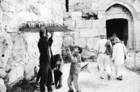 Image of sheet 19931210 photo 21: Mea Shearim Lutfi's Peace Land Galery in Ost- Jerusalem Altstadt. Regen in Altstadt. Am Markt Israeli Soldaten beobachten vom Damaskus Tor aus. Brotverkäufer. Rachel Freudenthal Portrait vor Spray Graffitti und beim einkaufen auf dem Shouk in Jerusalem mit Tochter Noa. Araber telefoniert und orthodoxe Juden nach dem Gebet am Shabes. Araber untersucht neue Unterhosen. Israel Palästina 1993