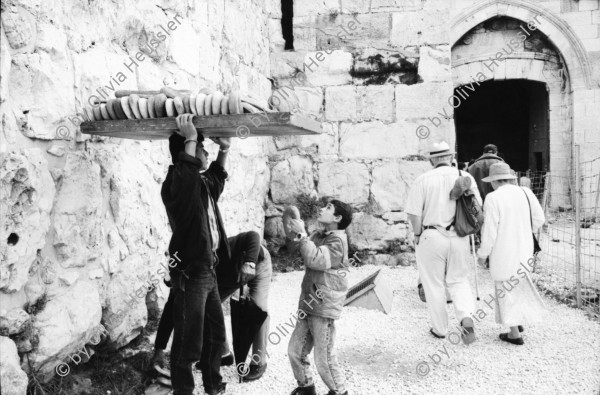 Image of sheet 19931210 photo 21: Mea Shearim Lutfi's Peace Land Galery in Ost- Jerusalem Altstadt. Regen in Altstadt. Am Markt Israeli Soldaten beobachten vom Damaskus Tor aus. Brotverkäufer. Rachel Freudenthal Portrait vor Spray Graffitti und beim einkaufen auf dem Shouk in Jerusalem mit Tochter Noa. Araber telefoniert und orthodoxe Juden nach dem Gebet am Shabes. Araber untersucht neue Unterhosen. Israel Palästina 1993