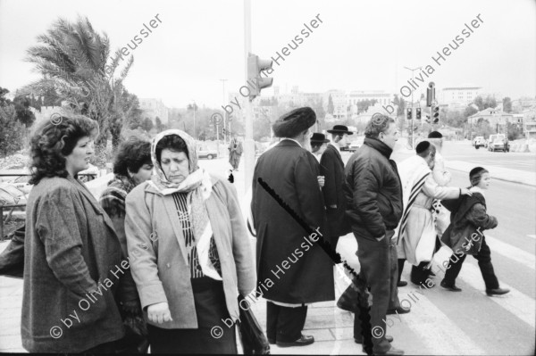 Image of sheet 19931210 photo 35: Mea Shearim Lutfi's Peace Land Galery in Ost- Jerusalem Altstadt. Regen in Altstadt. Am Markt Israeli Soldaten beobachten vom Damaskus Tor aus. Brotverkäufer. Rachel Freudenthal Portrait vor Spray Graffitti und beim einkaufen auf dem Shouk in Jerusalem mit Tochter Noa. Araber telefoniert und orthodoxe Juden nach dem Gebet am Shabes. Araber untersucht neue Unterhosen. Israel Palästina 1993