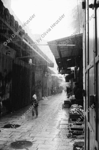 Image of sheet 19931210 photo 7: Mea Shearim Lutfi's Peace Land Galery in Ost- Jerusalem Altstadt. Regen in Altstadt. Am Markt Israeli Soldaten beobachten vom Damaskus Tor aus. Brotverkäufer. Rachel Freudenthal Portrait vor Spray Graffitti und beim einkaufen auf dem Shouk in Jerusalem mit Tochter Noa. Araber telefoniert und orthodoxe Juden nach dem Gebet am Shabes. Araber untersucht neue Unterhosen. Israel Palästina 1993