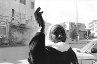 Image of sheet 19931250 photo 19: Protest Kundgebung Demonstration zum 26. Geburtstag von Georges Habasch's PLFP Frauen 
People's Liberation Front of Palestine in Ramallah West Bank Tränengas Einsatz brennende Autoreifen . Aniversery. Ramallah Palestine Palästina 1993 √ Palestinian woman with scarf on the street.