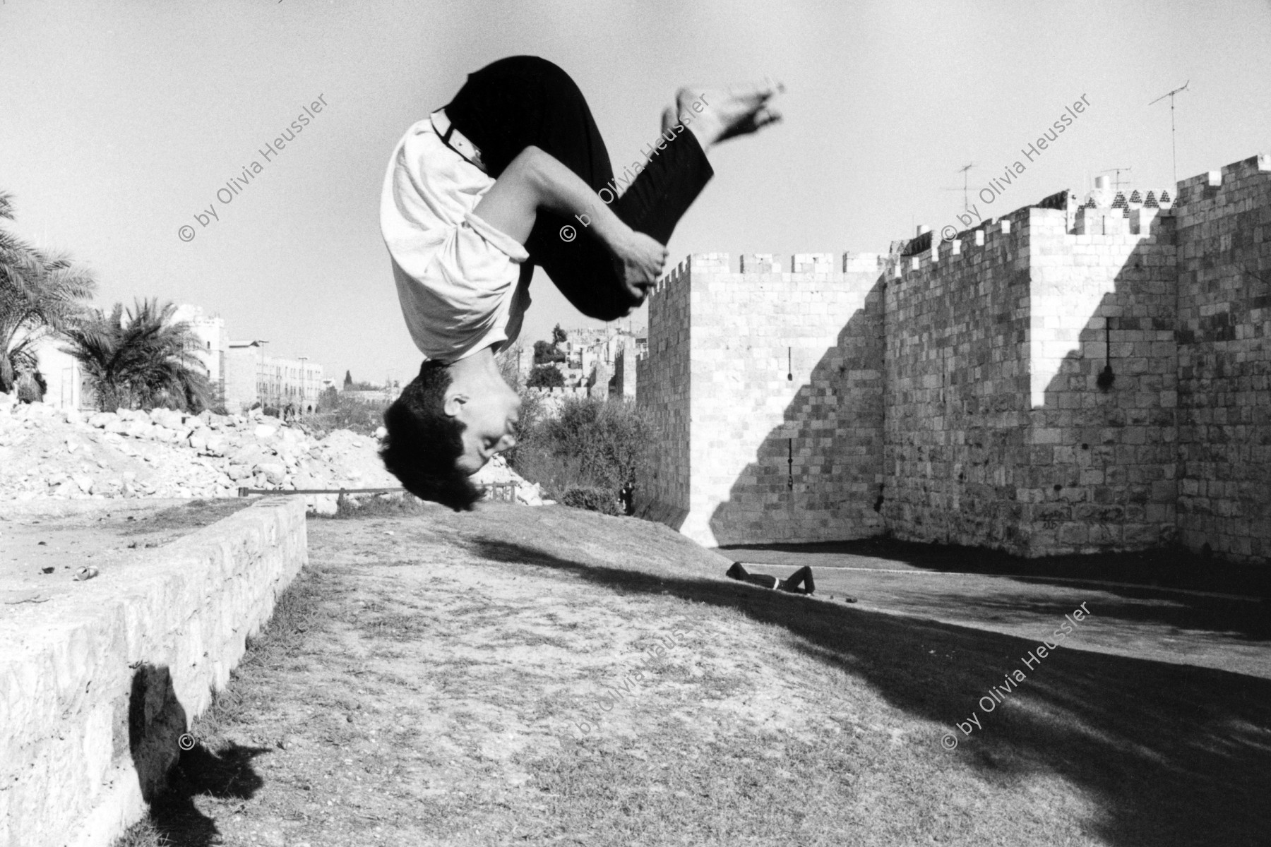 Image of sheet 19931270 photo 25: Junge macht Salto im Hintergrund die Stadtmauer von Jerusalem Israel 1993
√ acrobatics young man makes a salto in front of wall of oldtown