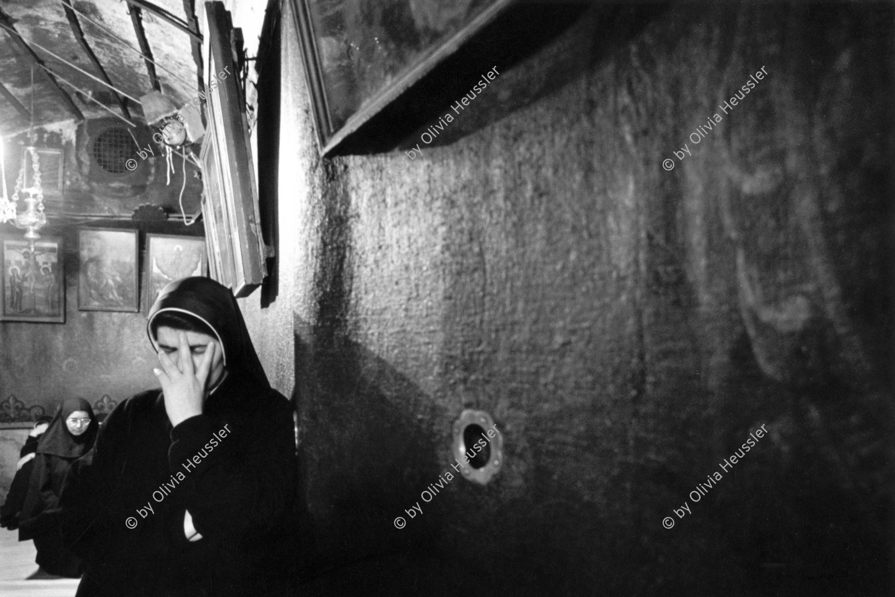 Image of sheet 19931420 photo 21: '02.00 Uhr Nachts eine Nonne während dem Gebet in der Geburtskirche Jesus Christus, Bethlehem, Palästina. 25.12.93'. Aus Femmes occupées
Palestine Religion
Die Geburtskirche (arabisch ‏كنيسة المهد‎, hebräisch ‏כנסיית המולד‎) ist die Kirche in Bethlehem, die über der vermuteten Geburtsstätte Jesu Christi errichtet wurde. Die Geburtskirche gehört zu den wenigen Beispielen vollkommen erhaltener Bauten aus frühchristlicher Zeit.

1993, by Olivia Heussler