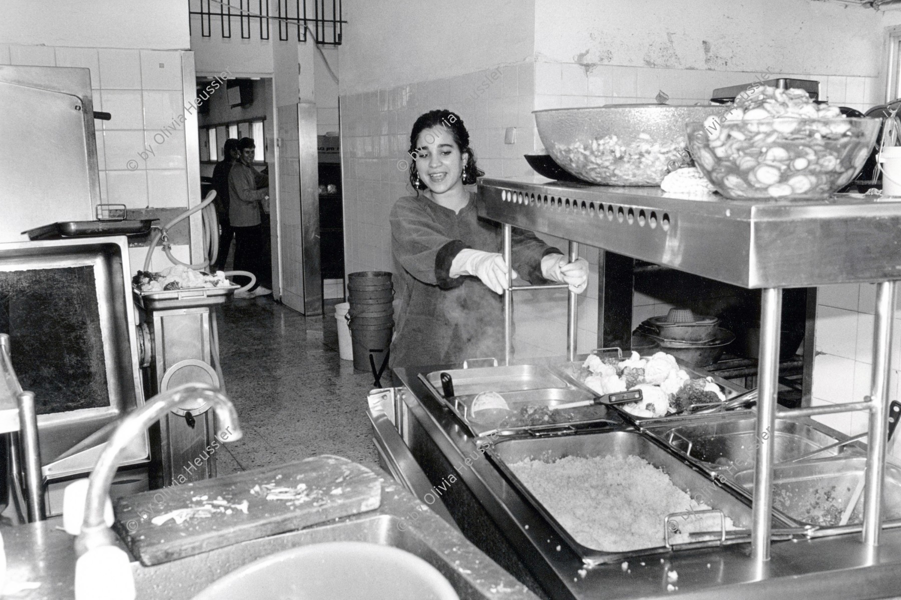 Image of sheet 19931470 photo 24: © 1993, Olivia Heussler / www.clic.li
Das Mittagessen wird angefahren. Kibbutz Samar 1993 © 1993, Olivia Heussler √
Israel Food Kitchen eating lunch
Samar (Hebrew: סָמָר‎‎) is a kibbutz in the Arabah valley in the far south of Israel. Located near Eilat, it falls under the jurisdiction of Hevel Eilot Regional Council. 
A kibbutz (Hebrew: קִבּוּץ / קיבוץ, lit. "gathering, clustering"; plural kibbutzim) is a collective community in Israel that was traditionally based on agriculture. Today, farming has been partly supplanted by other economic branches, including industrial plants and high-tech enterprises. Kibbutzim began as utopian communities, a combination of socialism and Zionism. In recent decades, some kibbutzim have been privatized and changes have been made in the communal lifestyle. A member of a kibbutz is called a kibbutznik (Hebrew: קִבּוּצְנִיק).