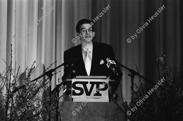 Image of sheet 19940080 photo 1: frtsg. Albisgüetli Tagung der SVP. in Zürich. Blasmusik Orchester. Stiefel Plakat 'Für eine sichere Zukunft in Freiheit' Herr Gregor Rutz ist Jungnachfolger.

The Swiss People's Party (German: Schweizerische Volkspartei, SVP), also known as the Democratic Union of the Centre (Italian: Unione Democratica di Centro, French: Union démocratique du centre, UDC), is a national conservative and right-wing populist political party in Switzerland. Chaired by Toni Brunner, but spearheaded by Christoph Blocher, the party is the largest party in the Federal Assembly, with 54 members of the National Council and 5 of the Council of States
 1994