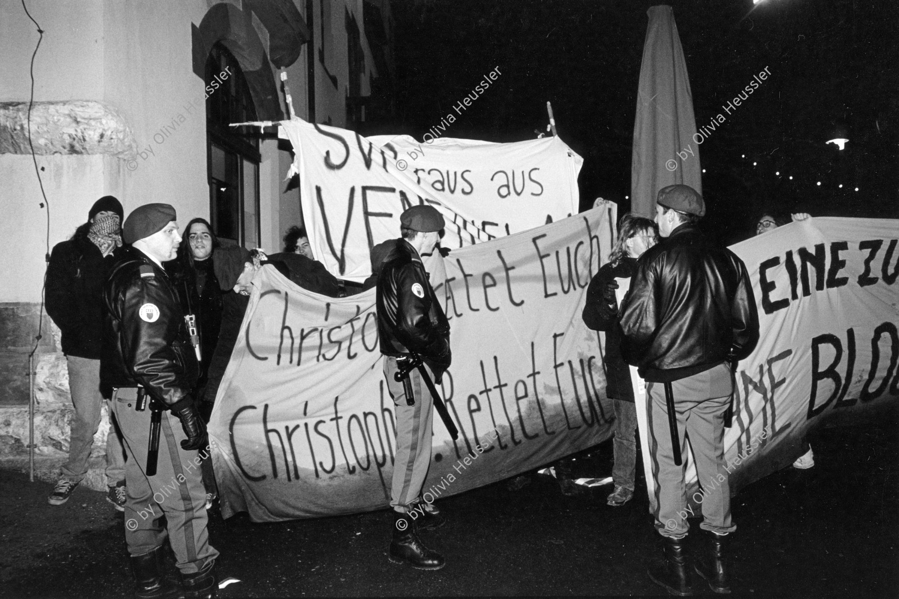 Image of sheet 19940090 photo 26: Demonstration Protest gegen SVP-Nationalrat Blocher vor dem Eingang des Albisgüetli, wo die Partei die traditionelle Tagung abhält. Zürich, 28.01.94

The Swiss People's Party (German: Schweizerische Volkspartei, SVP), also known as the Democratic Union of the Centre (Italian: Unione Democratica di Centro, French: Union démocratique du centre, UDC), is a national conservative and right-wing populist political party in Switzerland. Chaired by Toni Brunner, but spearheaded by Christoph Blocher, the party is the largest party in the Federal Assembly, with 54 members of the National Council and 5 of the Council of States.