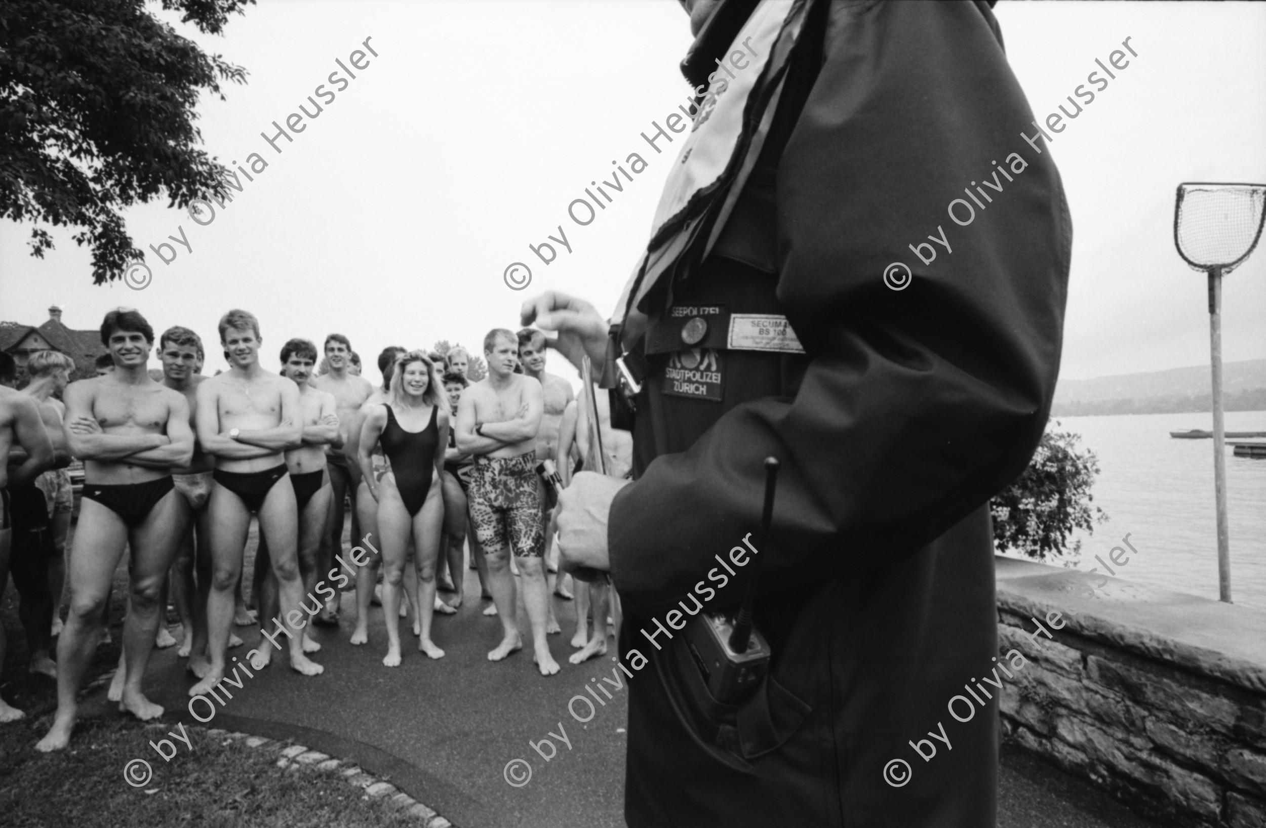 Image of sheet 19940310 photo 28: Ein Tag im Leben der Schweiz für Focale Contoir Suisse unterwegs
 mit Stadtpolizei Zürich, Herr Cortesi Pressestelle Urania Hauptwache um 6 Uhr 30. Polizei mit Hund Im Büro obszönes Alkoholiker Bäkeranlage Streifenwagen Limmat 4 grüsst sie. Befragung nach Brandstiftung durch Frau Polizeibeamtin Seiler (25) aus Steg Gampel und Herr Wachmeister Hochstrasser seit 21 Jahren im Dienst. Wache 4 mit Zellen Toilette und Frau Seiler. Waffe Einladen eines Verhafteten für den Spaziergang. 14.oo 69 PolizeiaspirantInnen vor der Seeüberquerung Wettkampf 1600m Beim Gang ins Wasser. Herr Leserf und Herr Zwahlen auf dem Polizeiboot. Zürich 1994