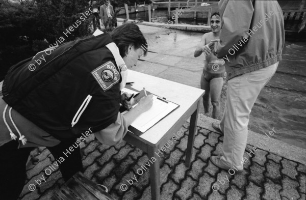 Image of sheet 19940330 photo 14: Polizeimotorboot mit Schweizer Fahne Polizeiboot Fredi Bachmann gewinnt PolizeiaspirantInnen Seeüberquerung in 32 min. Er wird in Tiefenbrunnen empfangen. AspirantInnen und Verkehrsbeamtinnen auf Photographien. Polizeimann Wehrli kontrolliert und filzt lybischer Drogendealer unter Mithilfe eines Kollegen mit Gummigeschoss gewehr in Achtungsstellung. Letten von der kornhaus Brücke aus. Süchtige fixen im Dreck. (mit Herr Cortesi Hauptwache Pressestelle unterwegs) Drug Letten Needlepark Zürich 1994