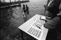 Image of sheet 19940330 photo 18: Polizeimotorboot mit Schweizer Fahne Polizeiboot Fredi Bachmann gewinnt PolizeiaspirantInnen Seeüberquerung in 32 min. Er wird in Tiefenbrunnen empfangen. AspirantInnen und Verkehrsbeamtinnen auf Photographien. Polizeimann Wehrli kontrolliert und filzt lybischer Drogendealer unter Mithilfe eines Kollegen mit Gummigeschoss gewehr in Achtungsstellung. Letten von der kornhaus Brücke aus. Süchtige fixen im Dreck. (mit Herr Cortesi Hauptwache Pressestelle unterwegs) Drug Letten Needlepark Zürich 1994