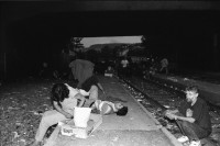 Image of sheet 19940360 photo 22: Mit Turicum (Presse Polizei Hr. Cortesi) Urania, unterwegs mit Polizei wachtmeister Bruno Burri, Nr. 23 und 29 etc. und am Letten. Burri kontrolliert Palästinenser und hilft Schwarzer Frau Drogenszene Leute unter Brücke mit Kreuz im Hintergrund. Schmutz am Boden Junkies fixen. im Dreck. Mann schleppt Mann mit Kartonschachteln weg. Zürich 1994 Junk Fixer