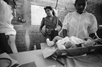 Image of sheet 19940490 photo 37: Charla von Dorothea und der franz. Krankenschwester in der Clinica MLO für die Frauen. Ueber Hygiene und Kindererziehung und Gesundheit. auch Aufklärung über Geschlechtsorgane bei Frau und Mann. Dorothea beim Sprechen mit Tafel. Schwangere auf Personenwaage mit Stiefel in der Hand. Frauen mit Kleinkinder in der Consulta . Behandlung. Wägen des Säugling Nicaragua 1994