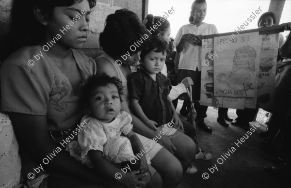 Image of sheet 19940490 photo 5: Charla von Dorothea und der franz. Krankenschwester in der Clinica MLO für die Frauen. Ueber Hygiene und Kindererziehung und Gesundheit. auch Aufklärung über Geschlechtsorgane bei Frau und Mann. Dorothea beim Sprechen mit Tafel. Schwangere auf Personenwaage mit Stiefel in der Hand. Frauen mit Kleinkinder in der Consulta . Behandlung. Wägen des Säugling Nicaragua 1994