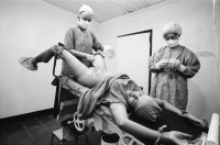 Image of sheet 19940610 photo 10: Zwei Frauen haben sich zur Unterbindung entschlossen. Die Operation wird im 'Haus für die natürliche Geburt' durch einem Arzt ausgeführt. Esteli Nicaragua 1994 health care, gesundheit arbeit frauen betten clinic sterilisation unterbindung deza  patientinnen mütter