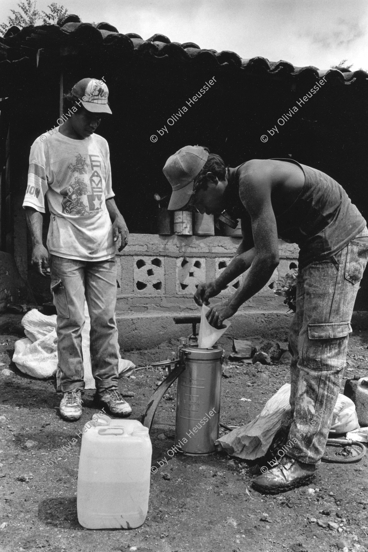 Image of sheet 19940620 photo 3: © 1994, Olivia Heussler / www.clic.li
Malariaprävention: Zwei Arbeiter füllen eine Pumpe mit Insektiziden, um Wohnäuser zu besprühen. Condega, Nicaragua 1994 √

Malaria Insecticide chemicals pump manual prevention