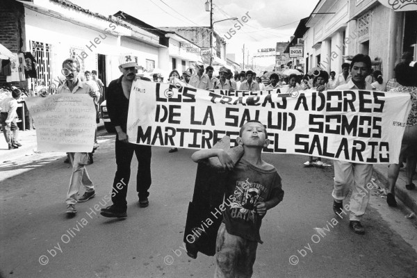 Image of sheet 19940710 photo 2: Ein junger Schuhputzer marschiert mit gestreckter Zunge vor einer Demo gegen die staatliche Lohnpolitik im Gesundheitswesen. Esteli, Nicaragua 1994 √

A shoecleaner marches in front of a demonstration against the cut of work and salaries in the medical health sector. protest