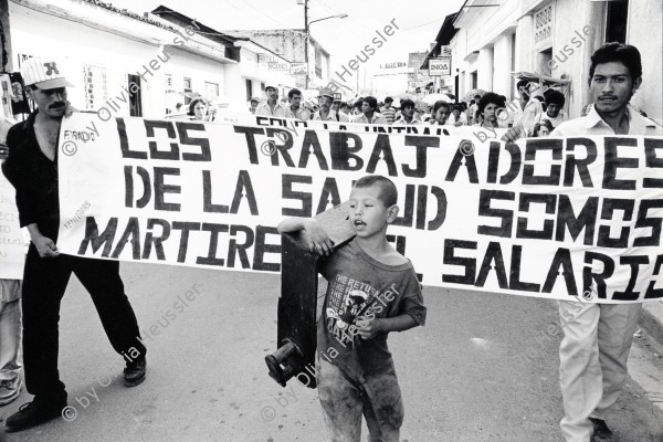 Image of sheet 19940710 photo 3: Ein junger Schuhputzer marschiert vor einer Demo gegen die staatliche Lohnpolitik im Gesundheitswesen. Esteli, Nicaragua 1994 √
A shoecleaner marches in front of a demonstration against the cut of work and salaries in the medical health sector. protest