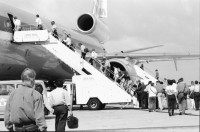 Image of sheet 19950080 photo 8: Flughafen Curacao Venezuela Flugzeug Triebwerk Bei Carmen zu Hause Mutter vor Ausgang Kind im Bett. Frauen sitzen herausgeputzt auf Bett mit kleinem Mädchen. Eine nicaraguanische Einwanderin arbeitet als Hausangestellte bei Familie. Mädchen springt auf Bett. Antonio und Ursula mit Hund im Auto. 1995 Costa Rica San José