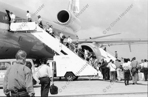 Image of sheet 19950080 photo 8: Flughafen Curacao Venezuela Flugzeug Triebwerk Bei Carmen zu Hause Mutter vor Ausgang Kind im Bett. Frauen sitzen herausgeputzt auf Bett mit kleinem Mädchen. Eine nicaraguanische Einwanderin arbeitet als Hausangestellte bei Familie. Mädchen springt auf Bett. Antonio und Ursula mit Hund im Auto. 1995 Costa Rica San José